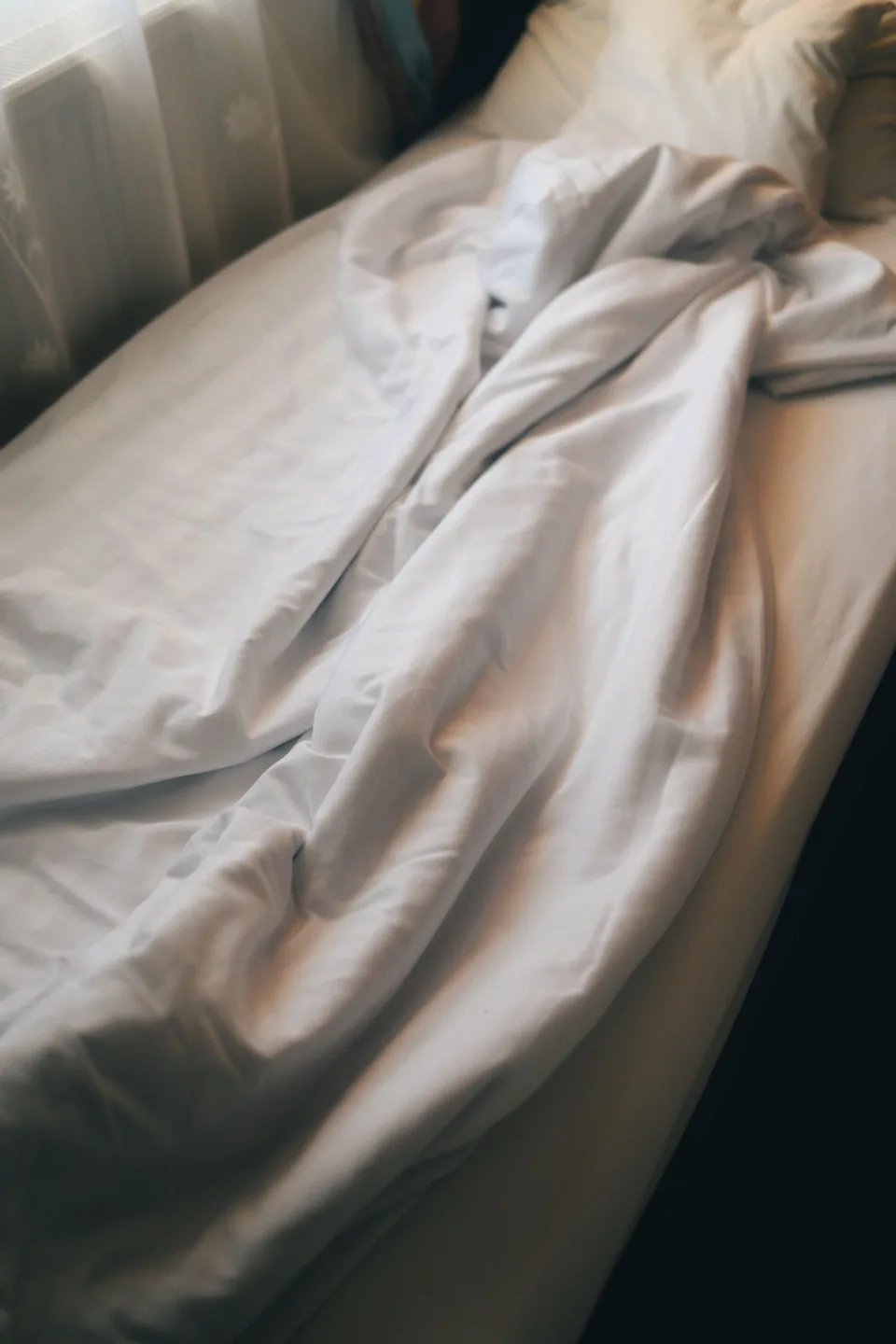 Linge de lit baigné d'une lumière douce du matin